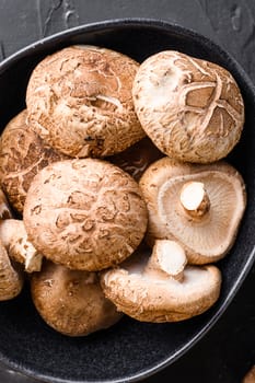 Shiitake mushrooms set on black background top view close up
