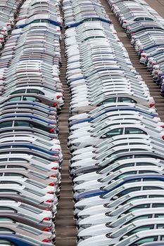 Rows of a new cars parked in a distribution center of a car factory. Top view to the parking in the open air.