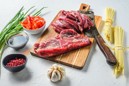 Asian food cooking - rice noodles with beef steak and noodles on white table side view