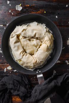 Greek spanakopita in backing pan filo spinach eggs feta top view on dark wooden background