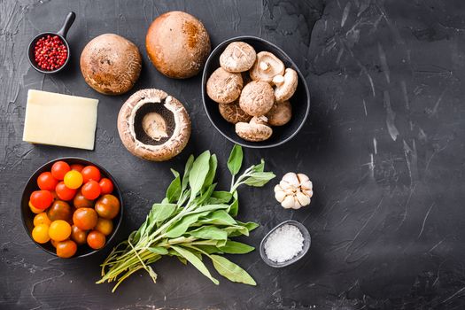 Baked garlicky mushrooms ingredients, portabello cheddar cheese and sage on black background. Top view, space for text