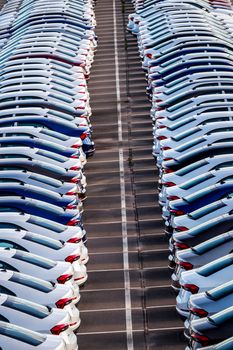 Rows of a new cars parked in a distribution center on a car factory on a sunny day. Top view to the parking in the open air.