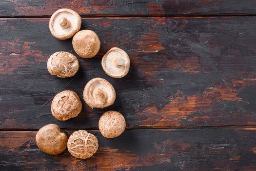 Shiitake mushrooms set on old wooden table, top view space for text