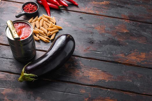 Aubergine penne ingredients eggplant pasta, pepper tomatoe sauce, on old dark wooden table side view space for text