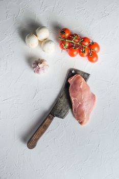 Raw chicken breast on butcher knife over white background