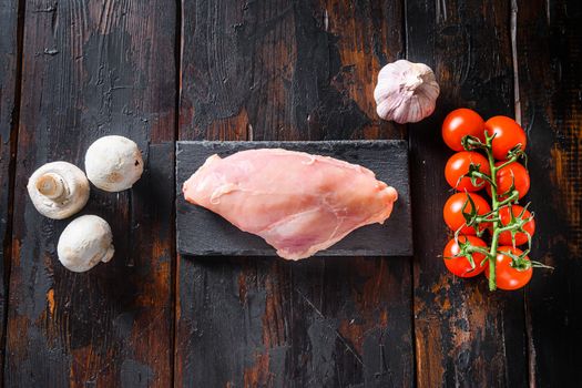  Raw organic chicken breast with meat butcher cleaver on a grey background. Food preparation, top view