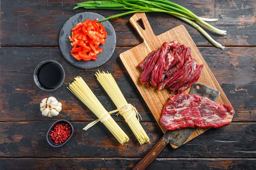 Cooking ingredients for Stir fry noodles with vegetables and beef . Machete steak and noodles on wooden background