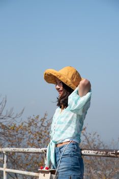 Asian pretty cute woman with hat relax at seaside city landscape viewpoint on mountain with happy and freedom emotion in concept travel, vacation, leisure in life