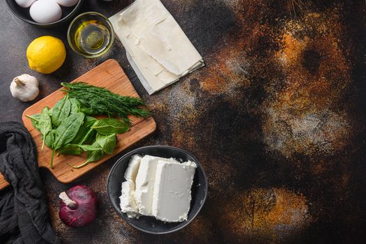 Traditional greek spanakopita ingredients filo spinach eggs feta top view on dark background space for text