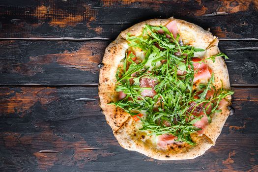 Homemade pizza with mozzarella, cheese and basil leaves onwooden planks. Top view space for text.