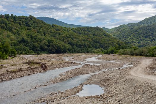 Mountain stonebed of river at the cloudy summer day