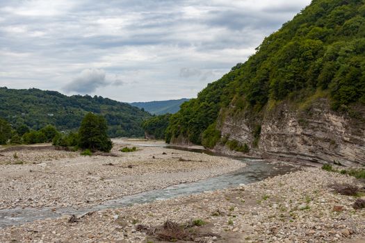 Mountain stonebed of river at the cloudy summer day