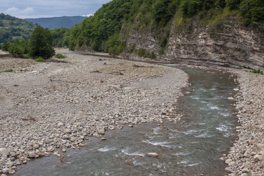 Mountain stonebed of river at the cloudy summer day