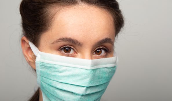 woman doctor in surgical mask facing camera, wearing protective filter to prevent coronavirus infection, airborne respiratory illness such as flu, 2019-nCoV. studio shot isolated on white background