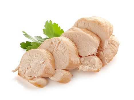 Isolated backed chicken fillet with green leaves of parsley