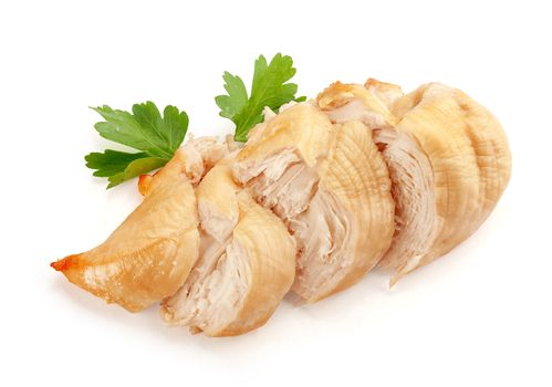 Isolated backed chicken fillet with green leaves of parsley