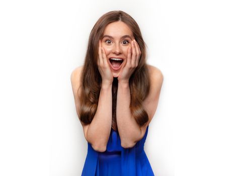 Image of excited screaming young woman standing isolated over white background. Looking camera. Woman in a blue dress. celebrating crazy and amazed for success. Woman happy and surprised.