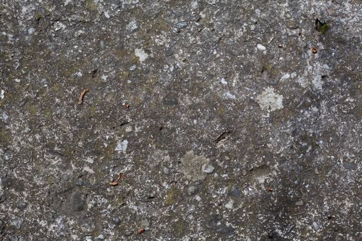 Texture of dark gray molded concrete with stones included