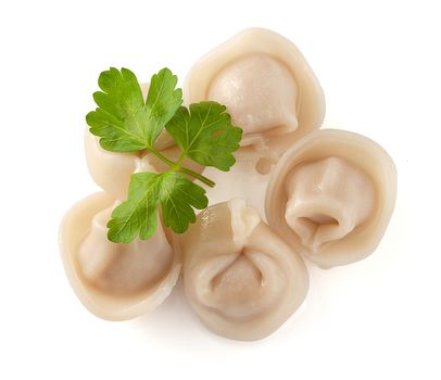 Five prepared dumplings with fresh green parsley on the white