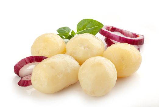 Isolated boiled potatoes with green basil and red onion