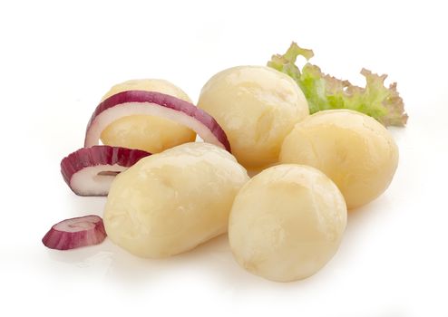 Heap of boiled potatoes with red onion and fresh green lettuce