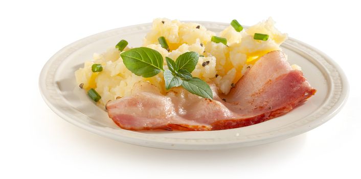 Mashed potatoes with bacon, basil and green onion on the white plate