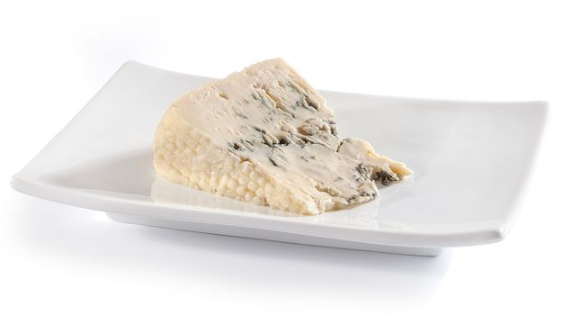 Piece of blue cheese on the white plate