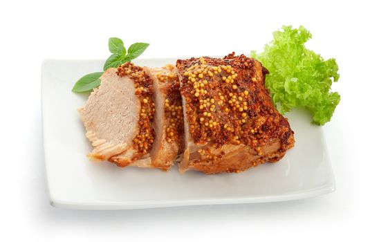 Baked pork with french mustard, basil and lettuce on the plate