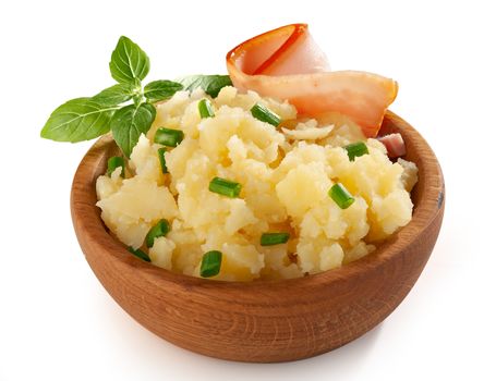 Mashed potatoes with bacon, fresh basil and green onion in the wooden bowl