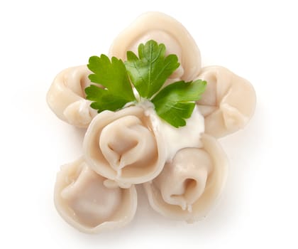 Handful of boiled dumplings with sourcream and fresh parsley leaf