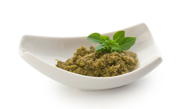 Pesto sauce in the gravy boat on the white