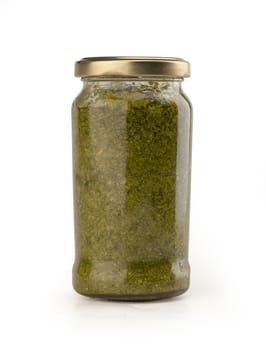 Pesto sauce in the glass jar on the white background