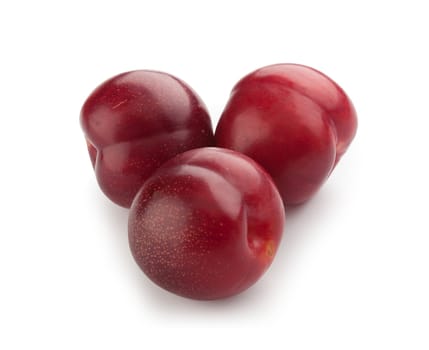 Isolated three whole red plums on the white background