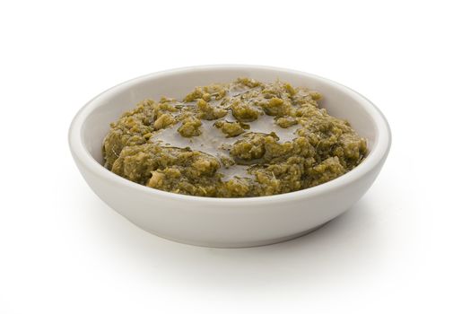 Pesto sauce in the gravy boat on the white