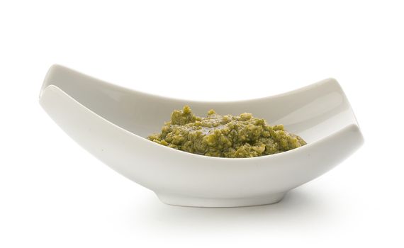 Pesto sauce in the gravy boat on the white