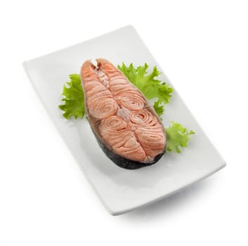 Steamed steak of salmon with fresh lettuce on the plate
