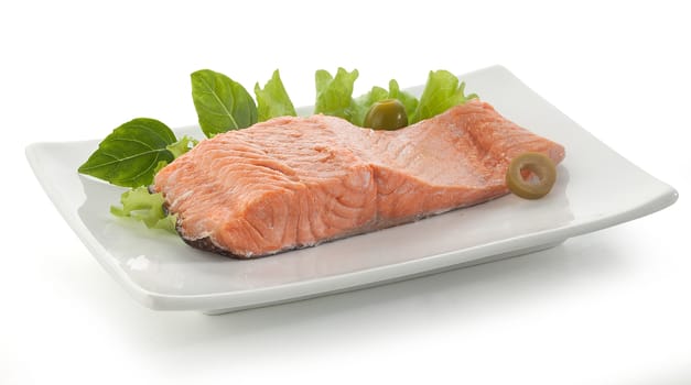 Fillet of trout with olives, basil and lettuce on the white plate