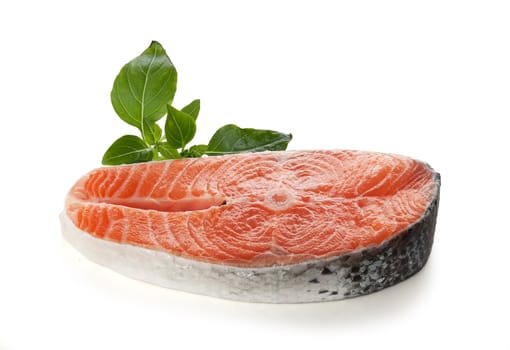Raw steak of salmon with green basil on the white