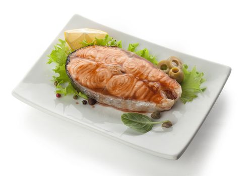 baked steak of salmon with olives and lemon dressed by pomegranate sauce