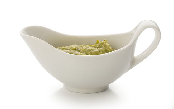 Pesto sauce in the gravy boat on the white