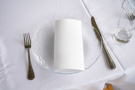 table setting transparent plate fork knife and invitation