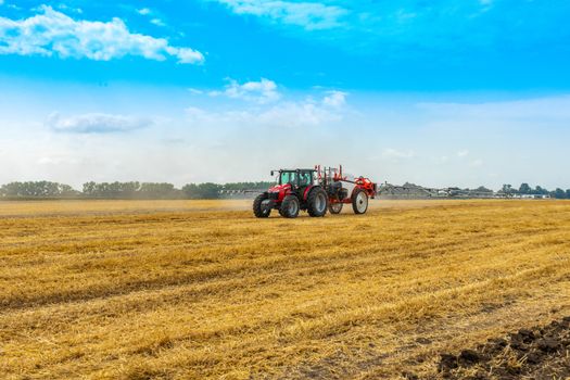 tractor with sprayer drives across the field