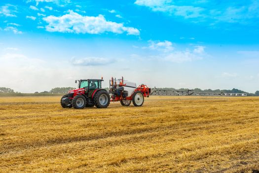 tractor with sprayer drives across the field