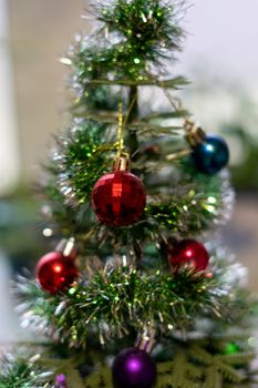 bright Christmas balls on a decorative small Christmas tree