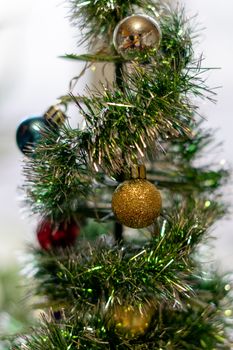 bright Christmas balls on a decorative small Christmas tree