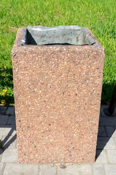 concrete trash can on green grass background