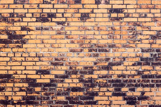 Old red and black brick wall from the time of the brick