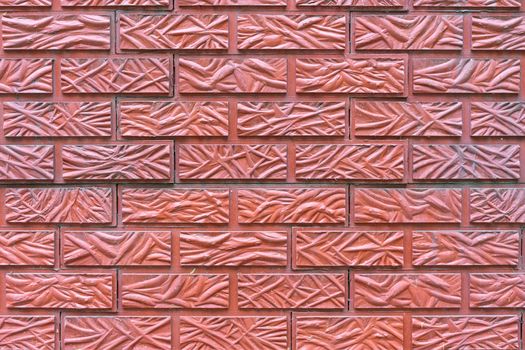 The wall is lined with red tiles with a brick texture
