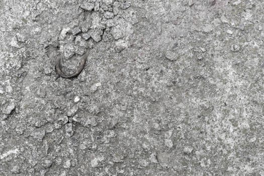 Old concrete slab with a bent metal hook. Background texture