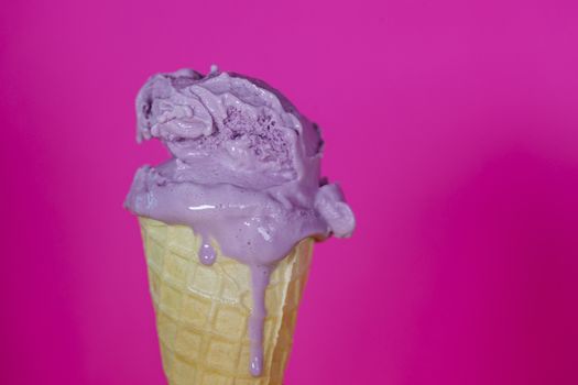 Melting purple ice cream close up on purple background